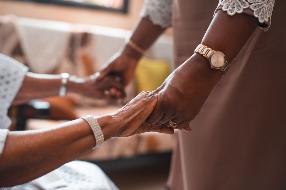 A close-up of two people holding hands, symbolizing support and togetherness.