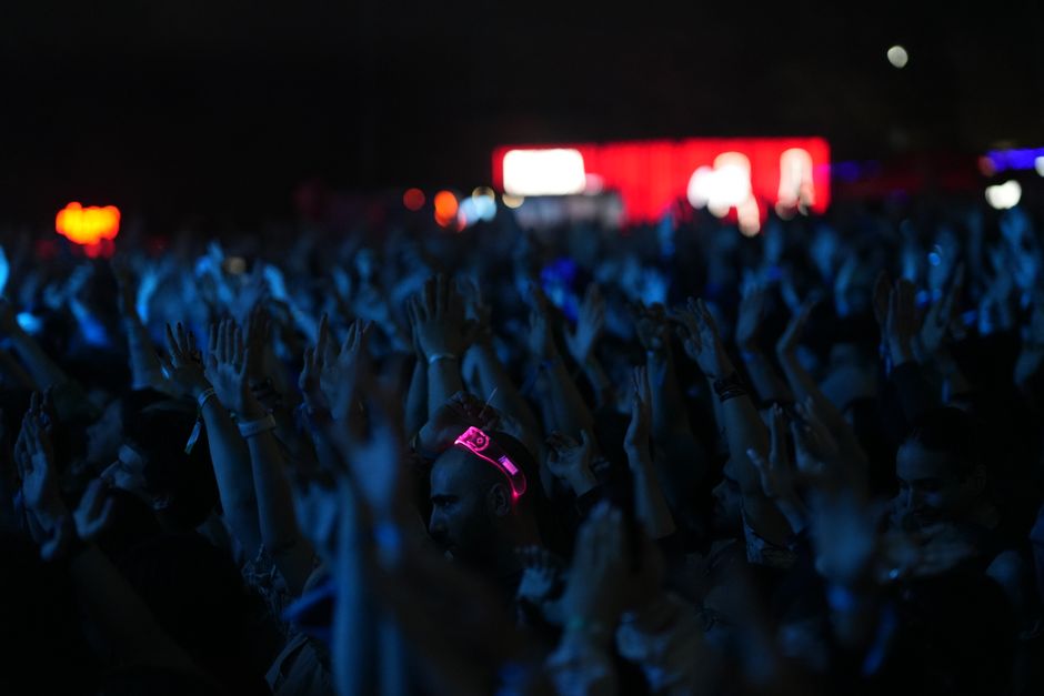 A lively concert scene with a crowd of people enjoying the music at night.