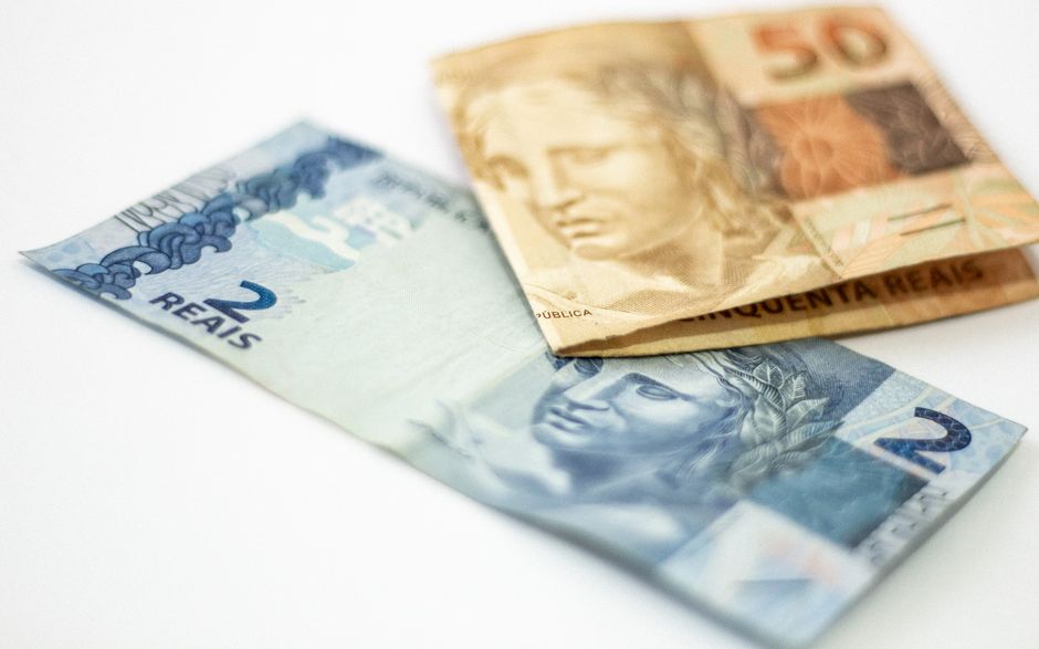 Close-up view of Brazilian banknotes, 2 and 50 reals, on a white background.