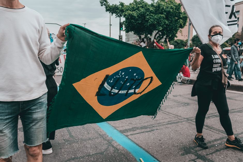 A group of protesters in Rio de Janeiro holding a Brazilian flag during a demonstration.